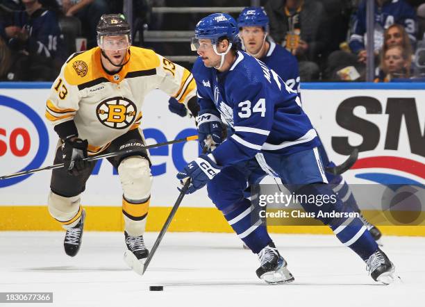 Auston Matthews of the Toronto Maple Leafs skates with the puck against Charlie Coyle of the Boston Bruins during the third period in an NHL game at...