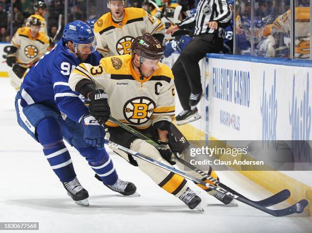 Brad Marchand of the Boston Bruins battles for the puck against John Tavares of the Toronto Maple Leafs during the third period in an NHL game at...