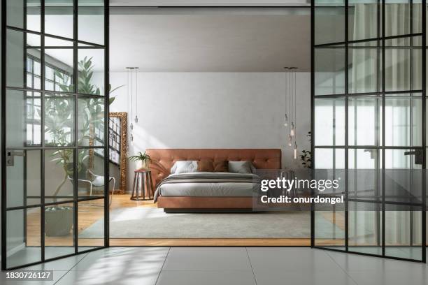 entrada de dormitorio moderno con cama doble, plantas de interior, luces colgantes y apertura de puerta de vidrio - cama de matrimonio fotografías e imágenes de stock