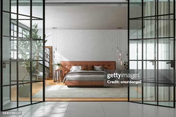 entrée de la chambre moderne avec lit double, plantes d’intérieur, suspensions et ouverture de porte en verre - king size bed photos et images de collection