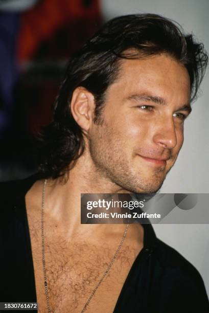 American actor John Corbett, wearing a black shirt open at the collar, attends the 1992 MTV Video Music Awards, held at the Edwin W Pauley Pavilion...