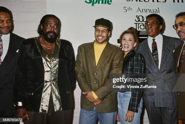 American singer-songwriter Barry White, wearing a black-and-gold jacket, American singer-songwriter Al B Sure!, wearing a tweed jacket over a yellow...
