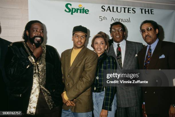 American singer-songwriter Barry White, wearing a black-and-gold jacket, American singer-songwriter Al B Sure!, wearing a tweed jacket over a yellow...