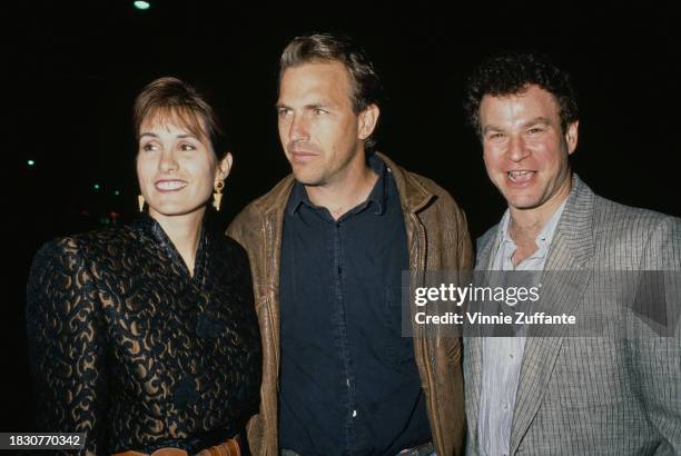 American actor and film director Kevin Costner, wearing a brown leather jacket over a black shirt, with his wife, Cindy Silva, who wears a...