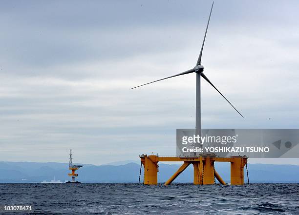 An offshore wind turbine 100m in height and bladespan of 40m, stands positioned in the sea off the coast of the town of Naraha in Fukushima...