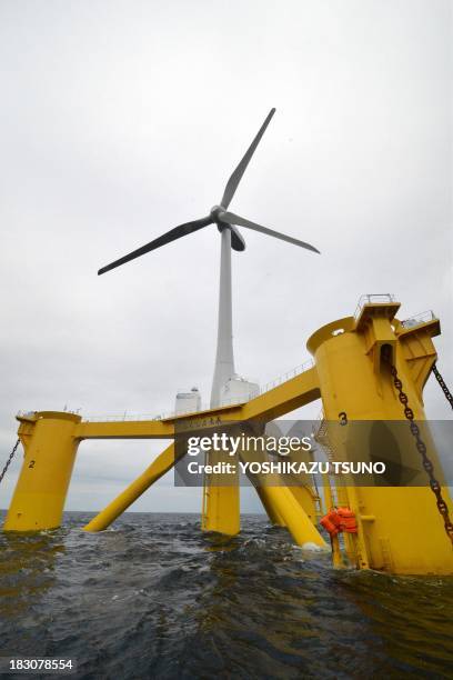 An offshore wind turbine 100m in height and bladespan of 40m, stands positioned in the sea off the coast of the town of Naraha in Fukushima...