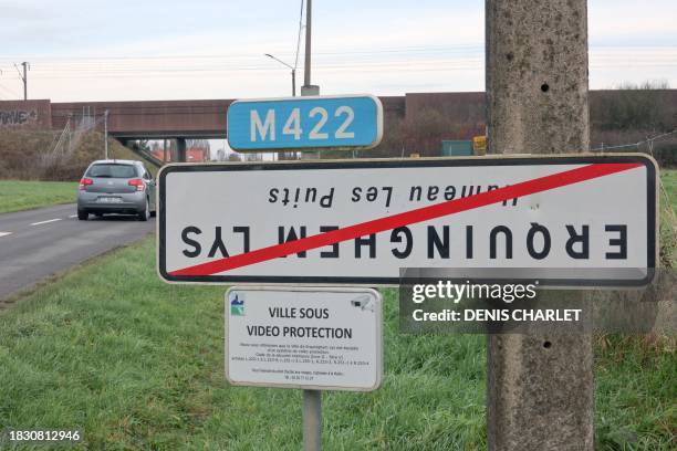 Photograph taken on December 7, 2023 shows a road sign indicating the end of the French city of Erquinghem-Lys, which has been turned upside down as...