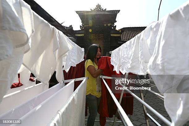 Woman hangs laundry outside a laundromat in Nusa Dua, Bali, Indonesia, on Friday, Oct. 4, 2013. Asia-Pacific leaders will seek momentum on talks for...