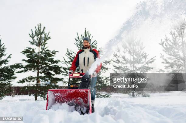 adult man removing snow with snowblower at heavy snowfall - snow blower stock pictures, royalty-free photos & images