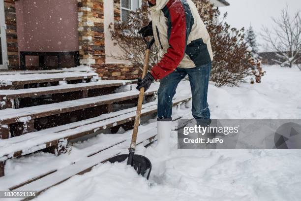 uomo adulto che rimuove la neve dal portico usando la pala - scavare foto e immagini stock