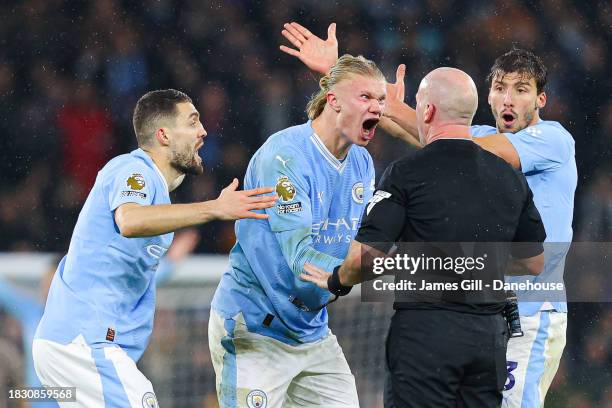 Referee Simon Hooper is surrounded by Erling Haaland, Mateo Kovacic and Ruben Dias of Manchester City after he stopped the game to award Manchester...