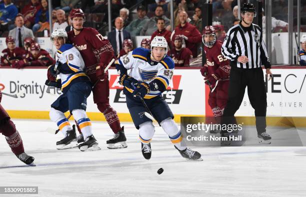 Jake Neighbours of the St Louis Blues passe the puck against the Arizona Coyotes at Mullett Arena on December 02, 2023 in Tempe, Arizona.