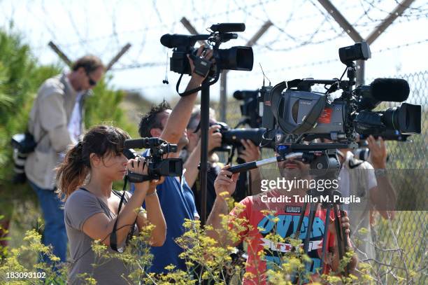 Broadcast crew work outside the Lampedusa airport where bodies of migrants lie on October 4, 2013 in Lampedusa, Italy. The search for bodies...