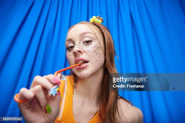 portrait of genz woman standing in front of a blue curtain background. - design by hand series celebration stock pictures, royalty-free photos & images