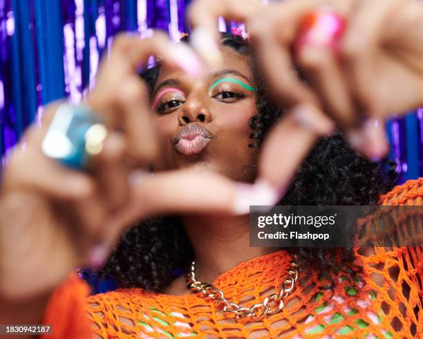 portrait of genz woman standing in front of a blue and purple metallic curtain background. - allegory stock pictures, royalty-free photos & images