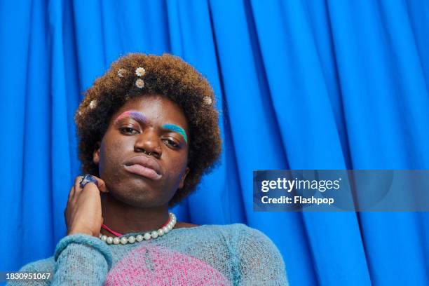 fashionable, quirky person standing in front of a  photo booth style blue curtain. - you & a stock pictures, royalty-free photos & images