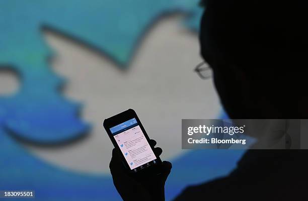 User checks a Twitter feed on the screen of an Apple Inc. IPhone 5 smartphone in this arranged photograph taken in London, U.K., on Friday, Oct. 4,...