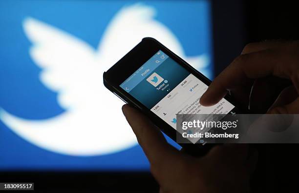 User scrolls through a Twitter feed on the screen of an Apple Inc. IPhone 5 smartphone in this arranged photograph taken in London, U.K., on Friday,...