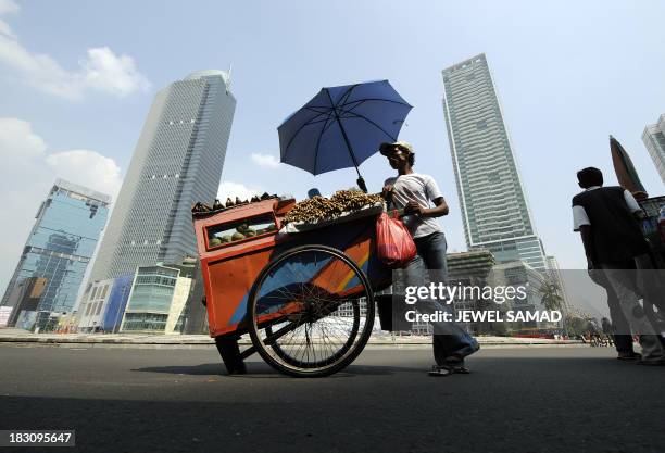 Food vendor takes advantage of the "Car Free Day" as he sets up his business on a main street in downtown Jakarta on June 29, 2008. Usually jammed by...