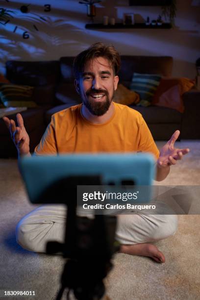 front view of a man using phone to do a video for his social media platforms. - content creation stock pictures, royalty-free photos & images