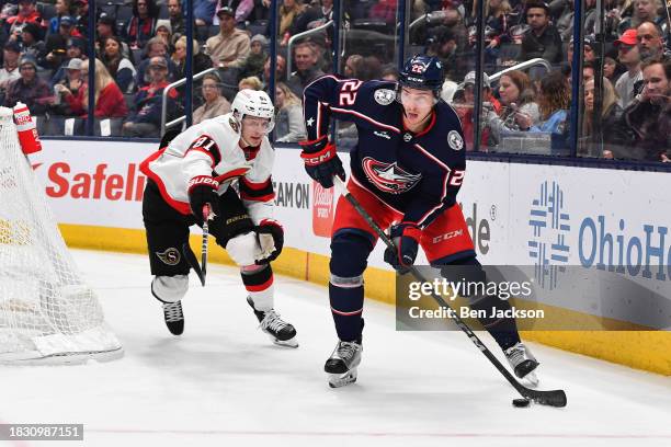 December 1: Jake Bean of the Columbus Blue Jackets looks to pass the puck away from Dominik Kubalik of the Ottawa Senators during the second period...