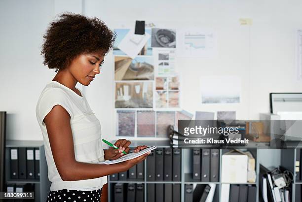 female creative taking notes on paper - file clerk stock pictures, royalty-free photos & images
