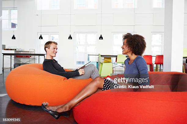 two creatives having a casual meeting - beanbag chair stockfoto's en -beelden