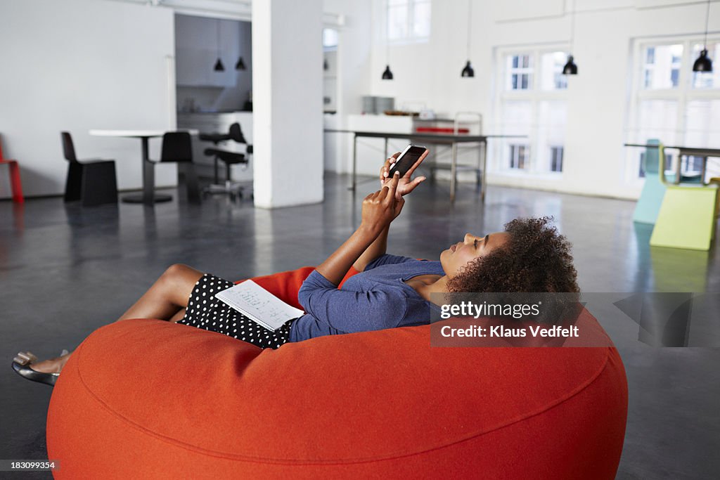 Businesswoman casually tjecking her smartphone