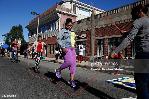 Queenie Howard of Roxbury plays double dutch on Blue Hill Avenue during the Circle the City initiative in Boston, Sept. 29, 2013.