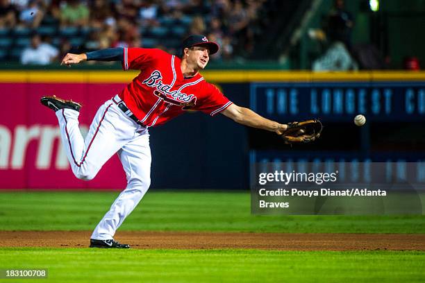 Elliot Johnson of the Atlanta Braves fields a ball against the San Diego Padres at Turner Field on September 13, 2013 in Atlanta, Georgia. The Padres...