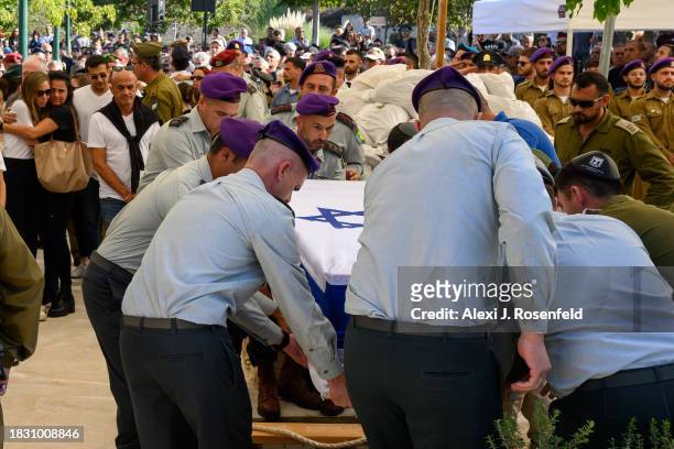The wife of Col. Asaf Hamami, commander of Gaza Division's Southern Brigade, grieves as the casket is lowered during the funeral at the Kiryat Shaul...