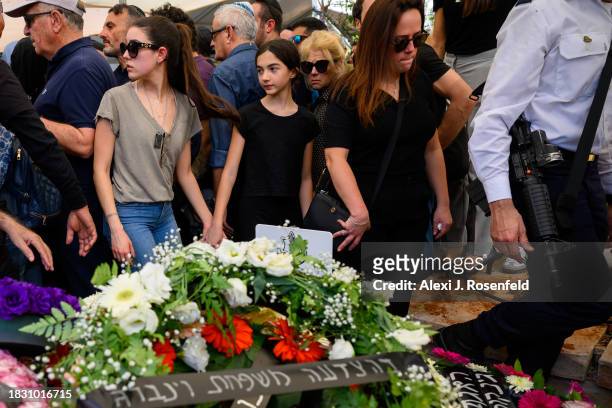 Immediate family members and friends walk past the grave Col. Asaf Hamami, commander of Gaza Division's Southern Brigade, during his funeral at the...