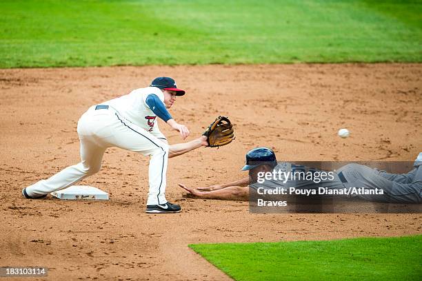 Elliot Johnson of the Atlanta Braves fields a ball as Will Venable of the San Diego Padres slides into second base against the at Turner Field on...