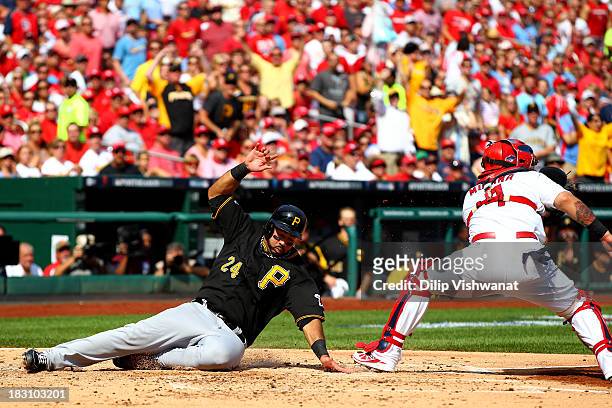 Pedro Alvarez of the Pittsburgh Pirates slides safely to score a run in the second inning before catcher Yadier Molina of the St. Louis Cardinals...
