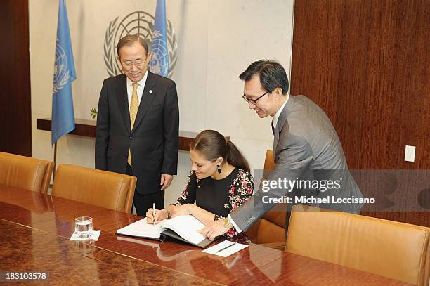 United Nations Secretary-General Ban Ki-moon looks on as Crown Princess Victoria of Sweden signs the UN guest book handed to her by UN Chief of...