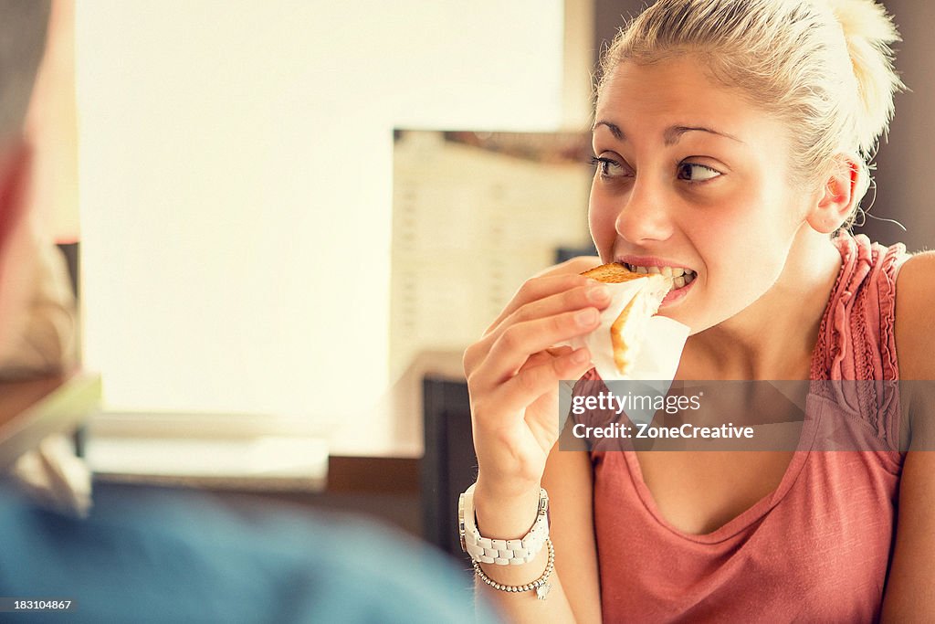 Young woman eat a toast at italian café