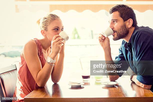 young couple drink coffee at italian café - incontro romantico foto e immagini stock
