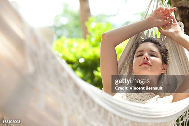 young woman relaxing in a hammock - hammock imagens e fotografias de stock