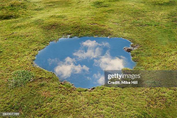 reflection of blue sky and clouds in puddle - puddle fotografías e imágenes de stock