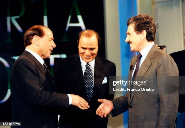 Candidates Prime Minister Silvio Berlusconi and Massimo D'Alema shake hands as presenter Bruno Vespa introduces talk show 'Porta A Porta' on tv...