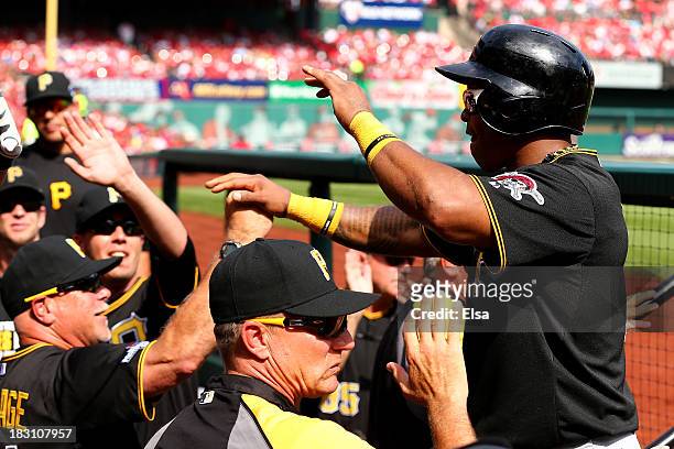 Marlon Byrd of the Pittsburgh Pirates is greeted at the dugout after scoring a run in the fifth inning against the St. Louis Cardinals during Game...