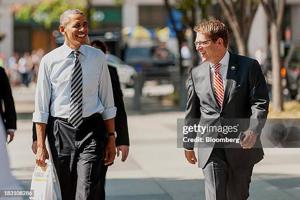 President Barack Obama, left, and Jay Carney, White House press secretary, walk back to the White House after picking up lunch at a Taylor Gourmet...