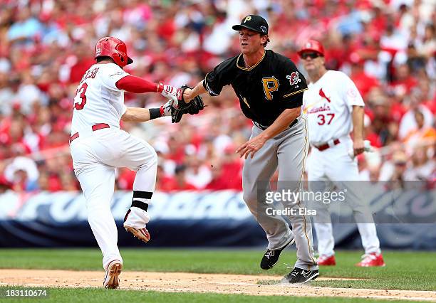Daniel Descalso of the St. Louis Cardinals is tagged out by Tony Watson of the Pittsburgh Pirates in the seventh inning during Game Two of the...