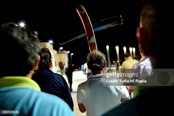 People attend the torchlight procession in memory of the victims of the immigrant boat disaster on October 4, 2013 in Lampedusa, Italy. The search...