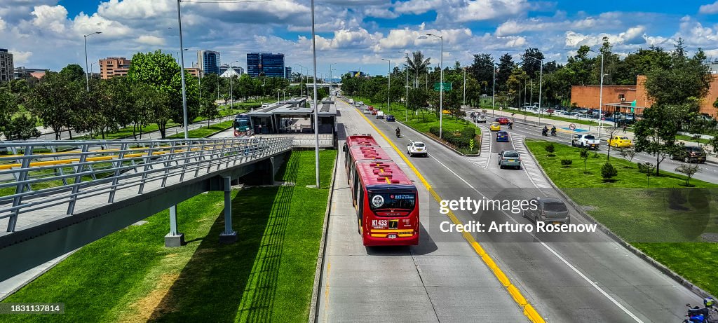 Cars and bus on a street with buildings in the background