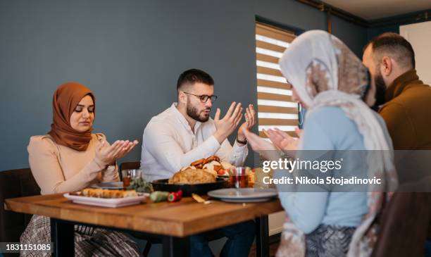 happy middle eastern family praying on ramadan - eastern european stockfoto's en -beelden