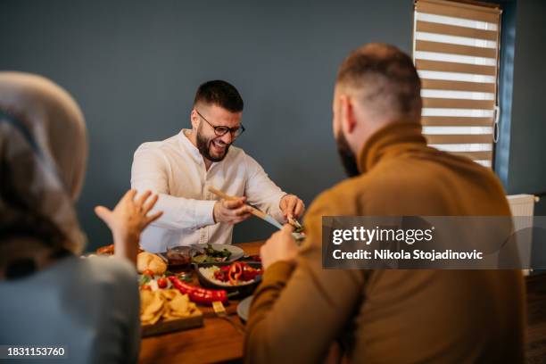 two muslim women serving dinner to their family - middagsbjudning bildbanksfoton och bilder
