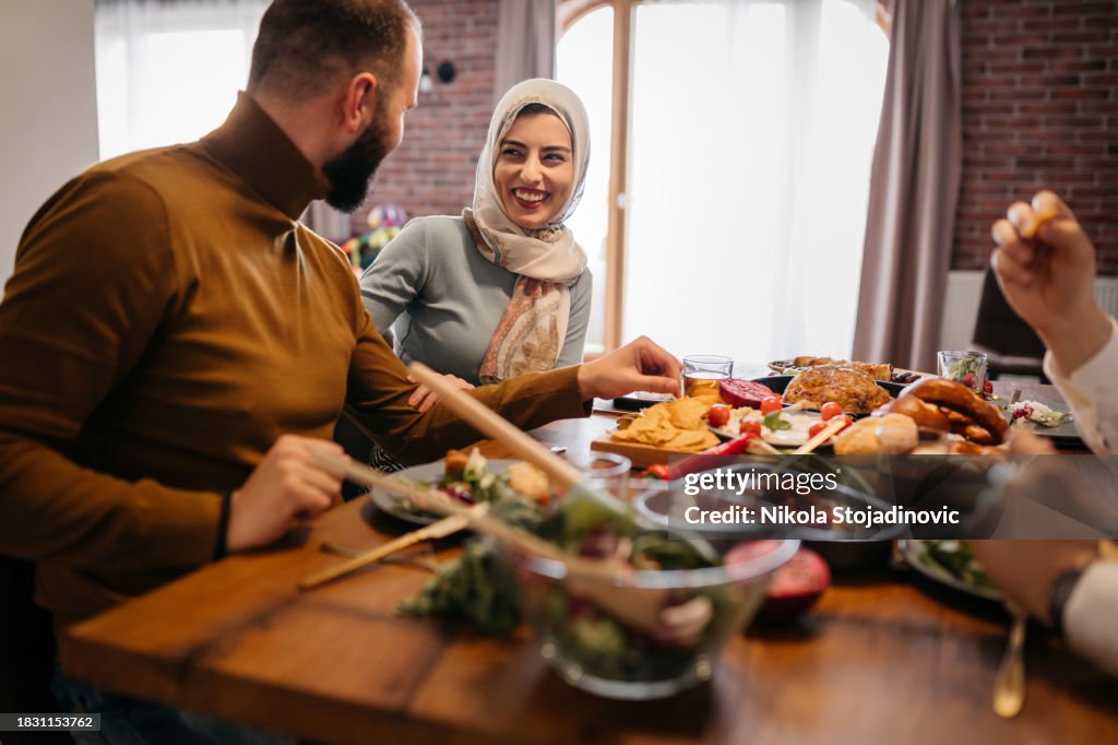 Jeune femme musulmane heureuse profitant d’un repas du Ramadan avec ses amis