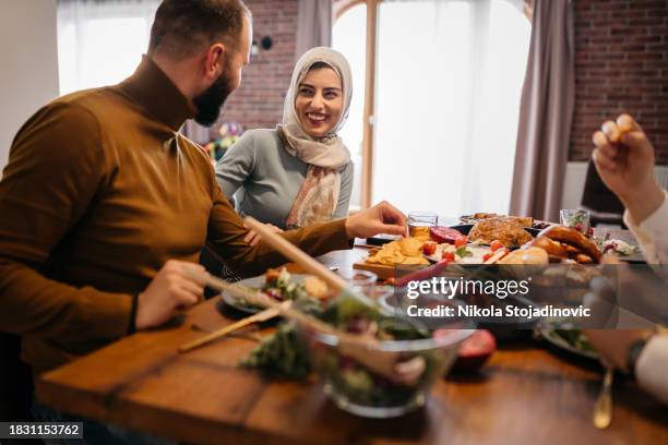 jeune femme musulmane heureuse profitant d’un repas du ramadan avec ses amis - iftar photos et images de collection