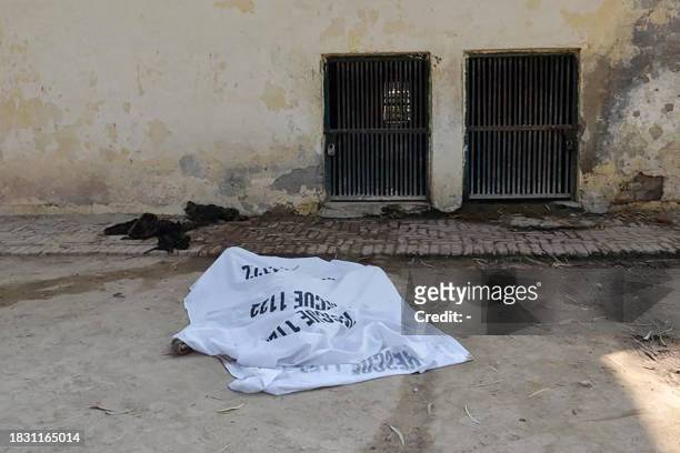 This picture taken on December 6, 2023 shows a covered dead body of a man who was mauled to death by tigers in a zoo in Bahawalpur district, in the...